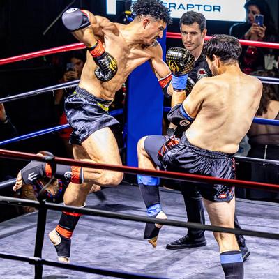 Two kickboxers exchanging strikes before an audience.