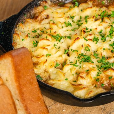 Shepherds pie served in a cast iron skillet with toast on the side.