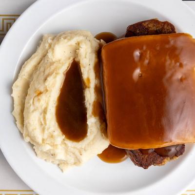 Hot meatloaf sandwich served with mashed potatoes and gravy.