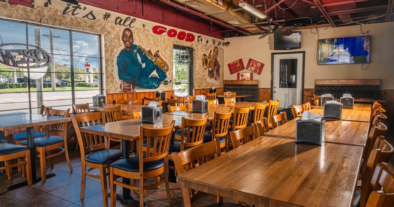 Interior, tables and chairs in dining area with painted walls