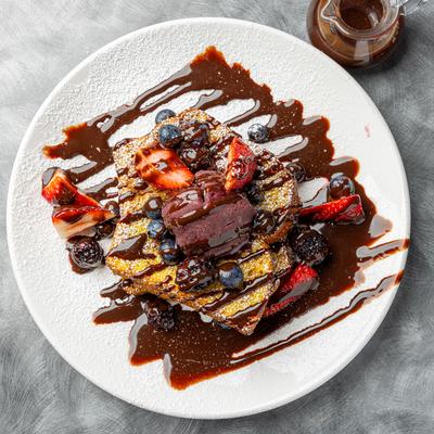 French Toast topped with fresh berries and a chocolate drizzle.