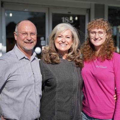 The owners and their adult child outside the restaurant.