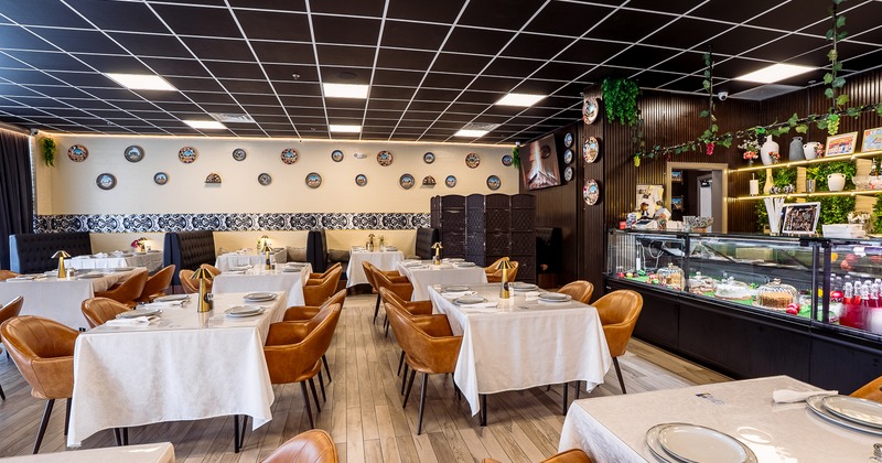 An elegant and modern interior dining area with set dining tables and brown leather chairs