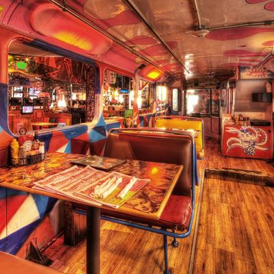 Diner, vintage decor, red and yellow booth seating, colorful murals, and wood floor