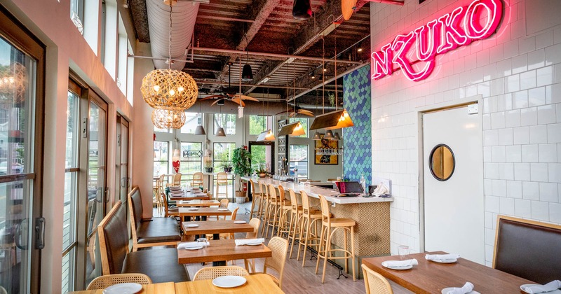 Interior, a bar with bar stools on the right, tables and chairs on the left