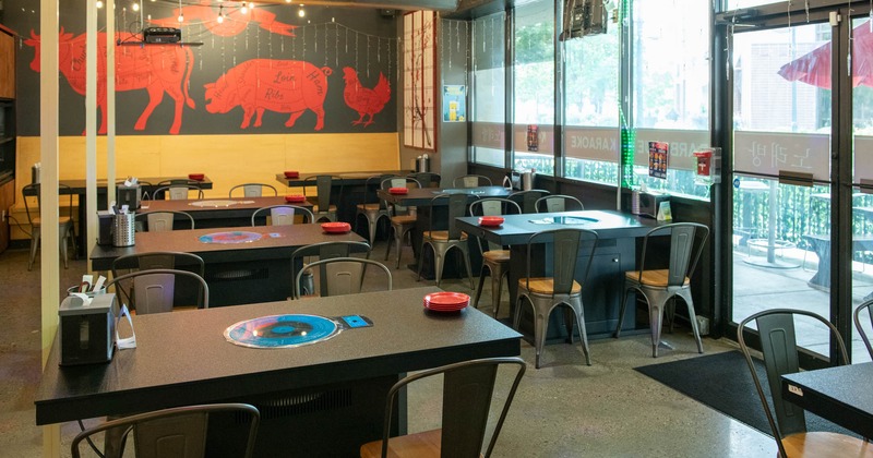 Interior seating space with tables, metal chairs and red wall illustrations of animals