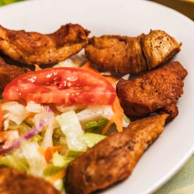 Fried chicken served with lettuce and tomato slices, close-up.