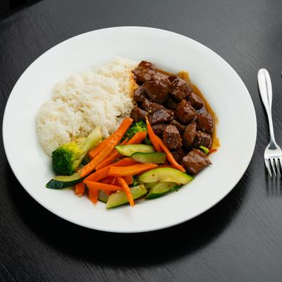 Tender beef cubes in sauce with white rice and sauteed vegetables.
