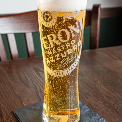 Tall glass of beer served on a woden table.