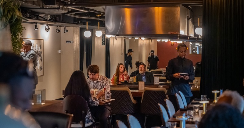 Modern restaurant interior of the dining area, guests chatting and enjoying their food and drinks