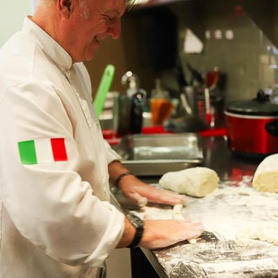 Chef preparing dough in a kitchen.