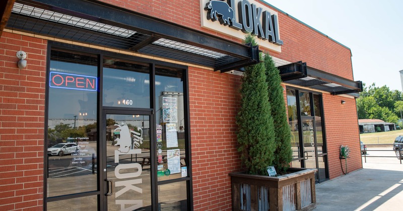 Restaurant exterior with signage and a neon 'Open' sign