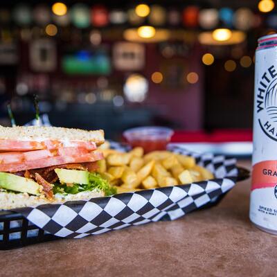 Bacon, Lettuce, Tomato & Avocado Sandwich basket with fries and can White Claw