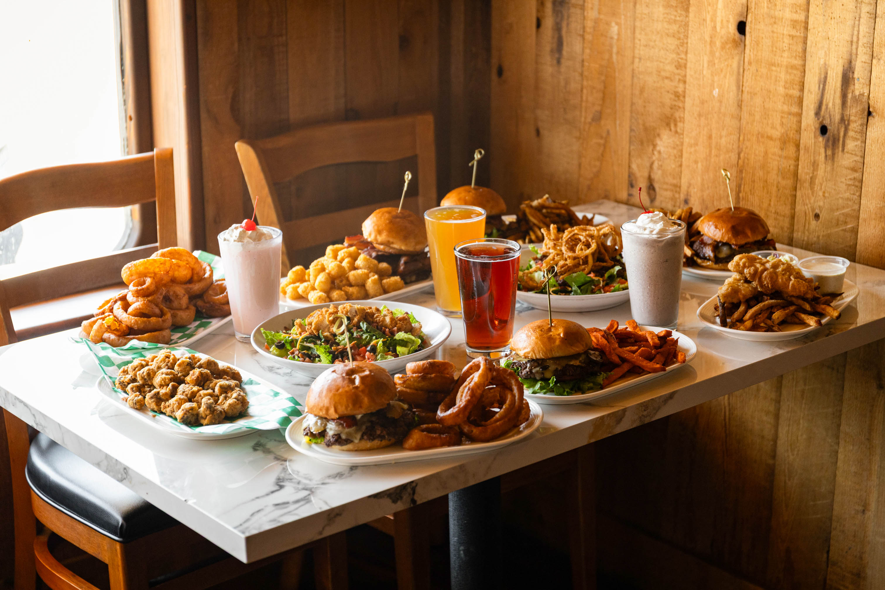Mammoth Burger Co. food spread with burgers, fries and shareable appetizers