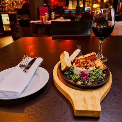 Baked camembert cheese with toasted bread and microgreens, served with red wine.