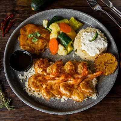 Butter shrimp plate with side rice and vegetables, top view.