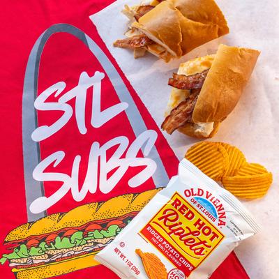Blue Note sub and a bag of chips on a red t-shirt with STL SUBS and a sandwich graphic.