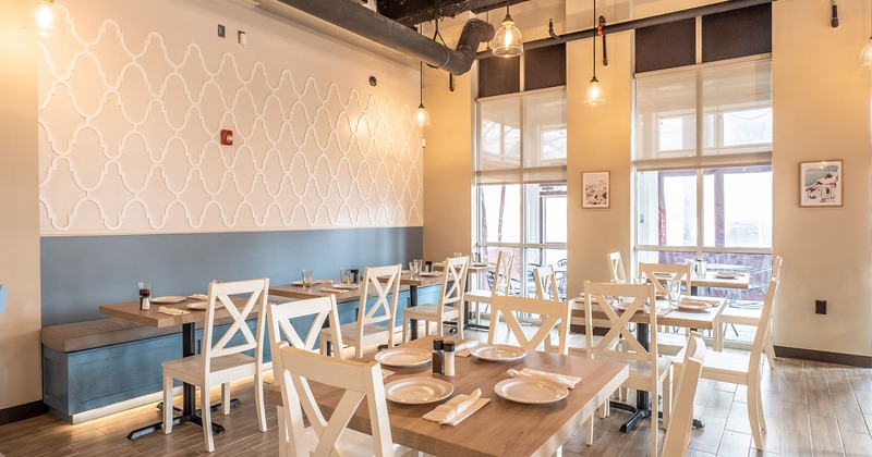Interior, dining tables with tableware ready for guests