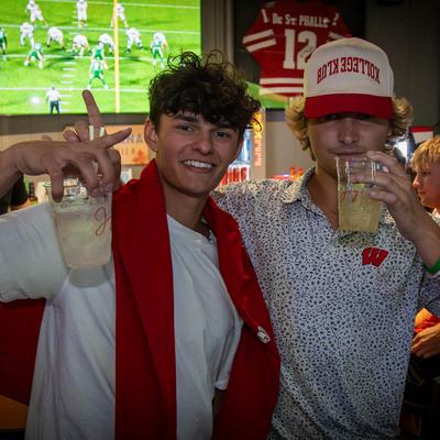 Two people holding drinks and posing.