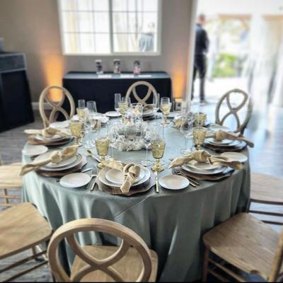 Interior, a round table for eight with tablecloth, tableware, cutlery, and glasses.