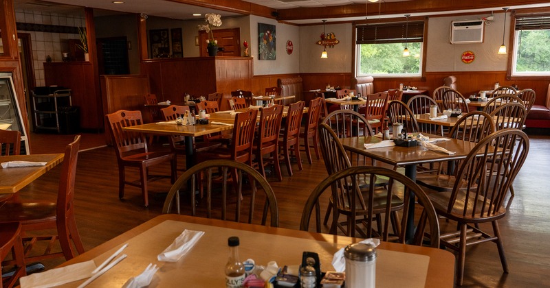 Spacious, cozy, and rustic interior dining area with set dining tables