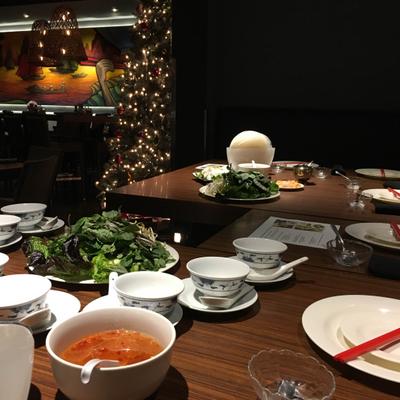 Fully set table with a bowl of soup, salad, and empty bowls and plates.