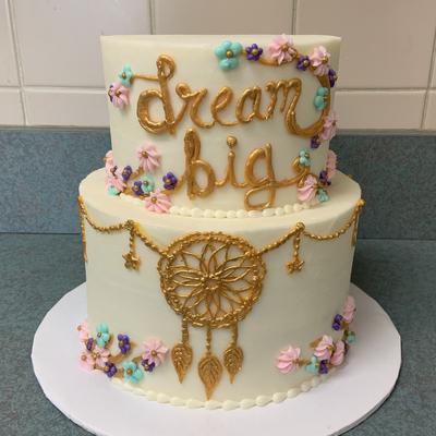 A two tiered cake with dream catcher decoration and the words dream big tiered cakes