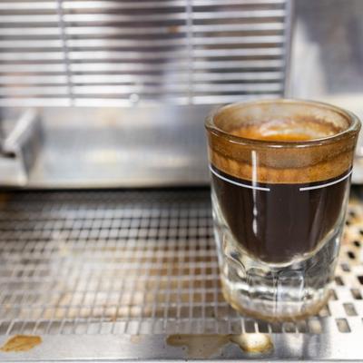 A freshly brewed shot of espresso sitting on a drip tray.