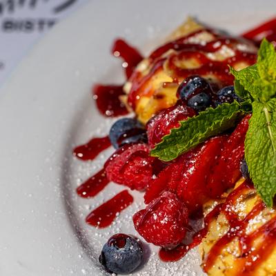 Berry-topped French toast drizzled with a rich crimson coulis.