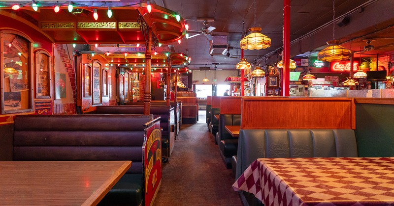Spacious dining area with comfortable upholstered booths and  wooden tables