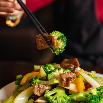 Chopsticks with a bite of Beef and Broccoli.