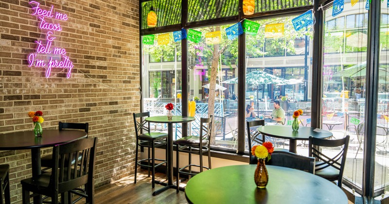 Tables with bar stools next to large windows