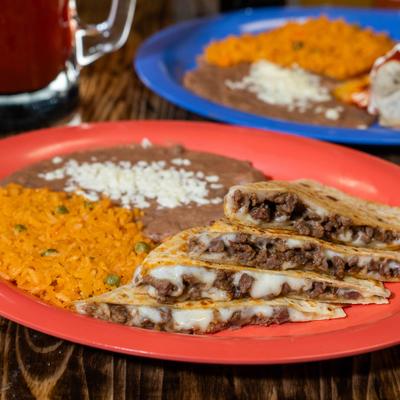 Quesadillas with steak and cheese, served with rice and refried beans.