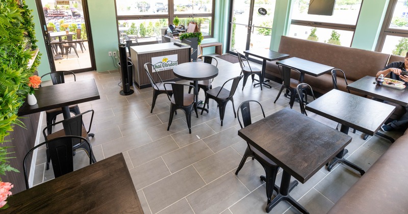 A bright casual dining restaurant with light blue walls, featuring metal tables and chairs