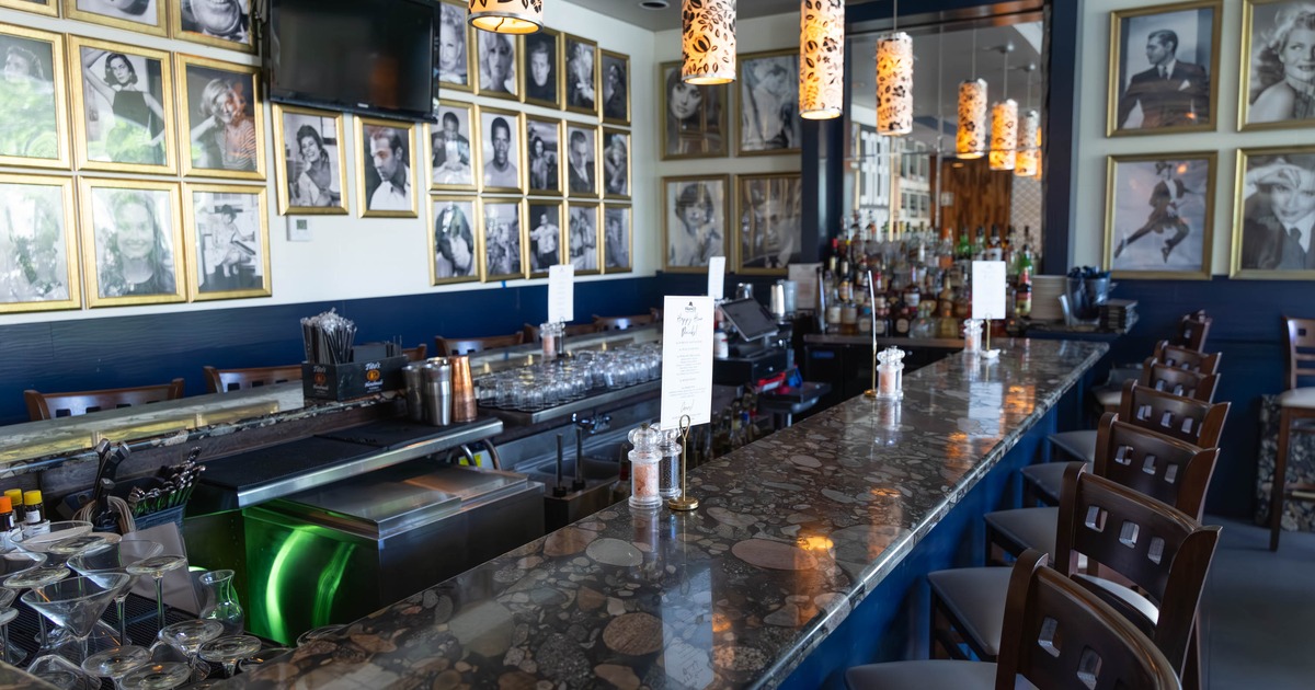 Bar interior - a stone countertop, floral pendant lights and framed photos on the wall