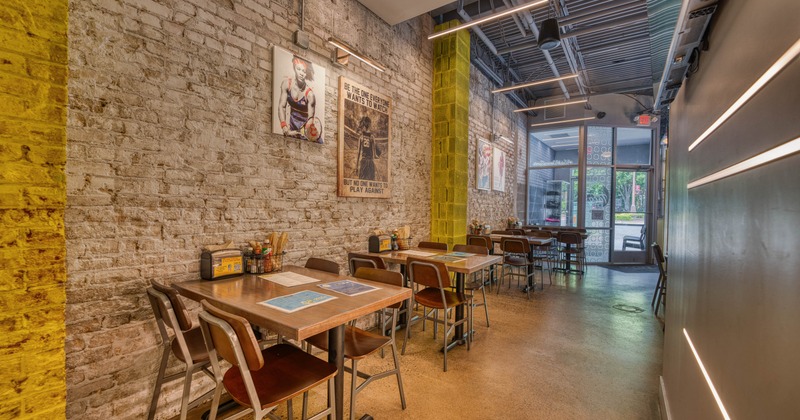 Interior with brick walls, wooden tables and exposed ceiling beams.