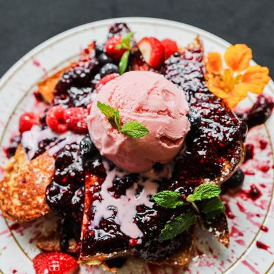 French toast topped with berry compote, fresh berries and scoopp of ice cream.