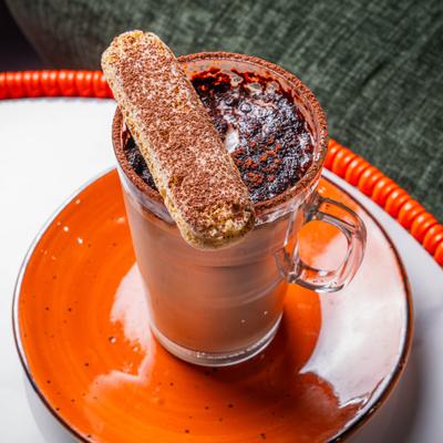 Chocolate latte drink topped with a ladyfinger cookie.