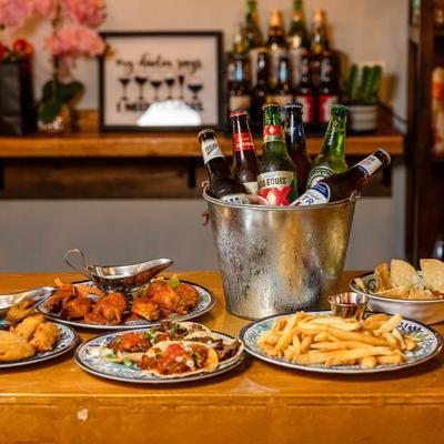 Table spread featuring a metal ice bucket filled with bottled drinks and various dishes.