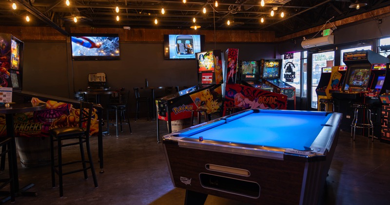 Interior, open space games room, various types of pinball and arcade games, pool tables