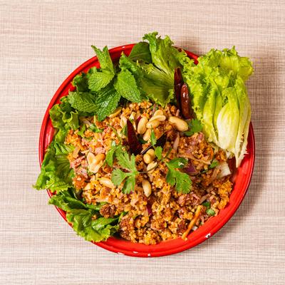 Crispy Thai rice salad with peanuts, herbs, chilies, and fresh lettuce.