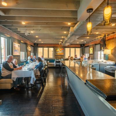 The restaurant interior featuring a long wooden bar top and booth seating.
