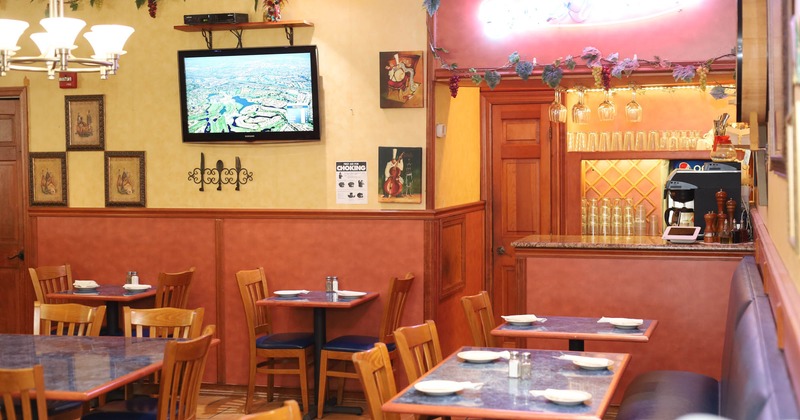 The seating area, pictures, and TV screen are on the wall, and the bar is on the right.