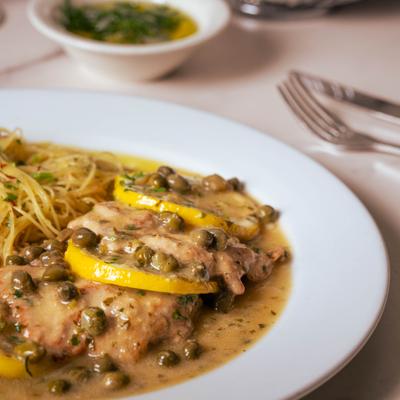 Veal piccata in lemon caper sauce served with pasta.