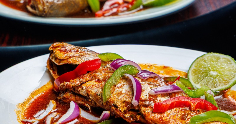 Fish in red sauce, with bell peppers and onions