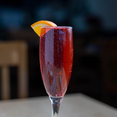 Mimosa cocktail garnished with a slice of orange.