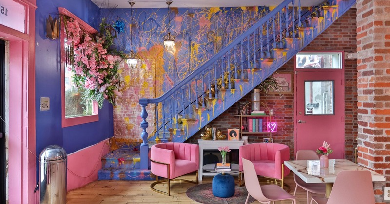 Interior, low armchairs with glass coffee table, book shelves, stairs covered in paint splashes