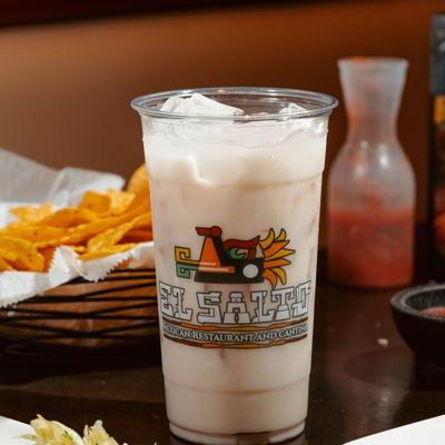 Horchata drink served on ice in a branded plastic cup.