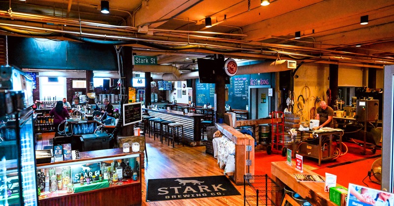 Brewery interior with bar and high-top seating, guests, and brewing equipment