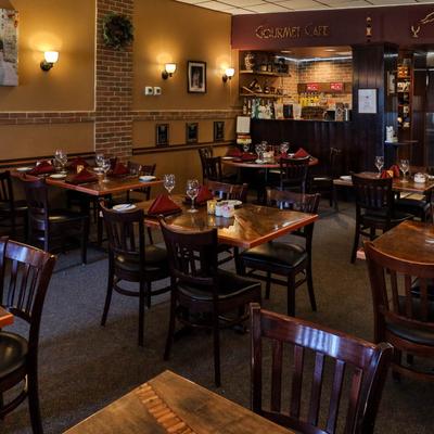 Dining area with set tables, chairs and a view of the bar.